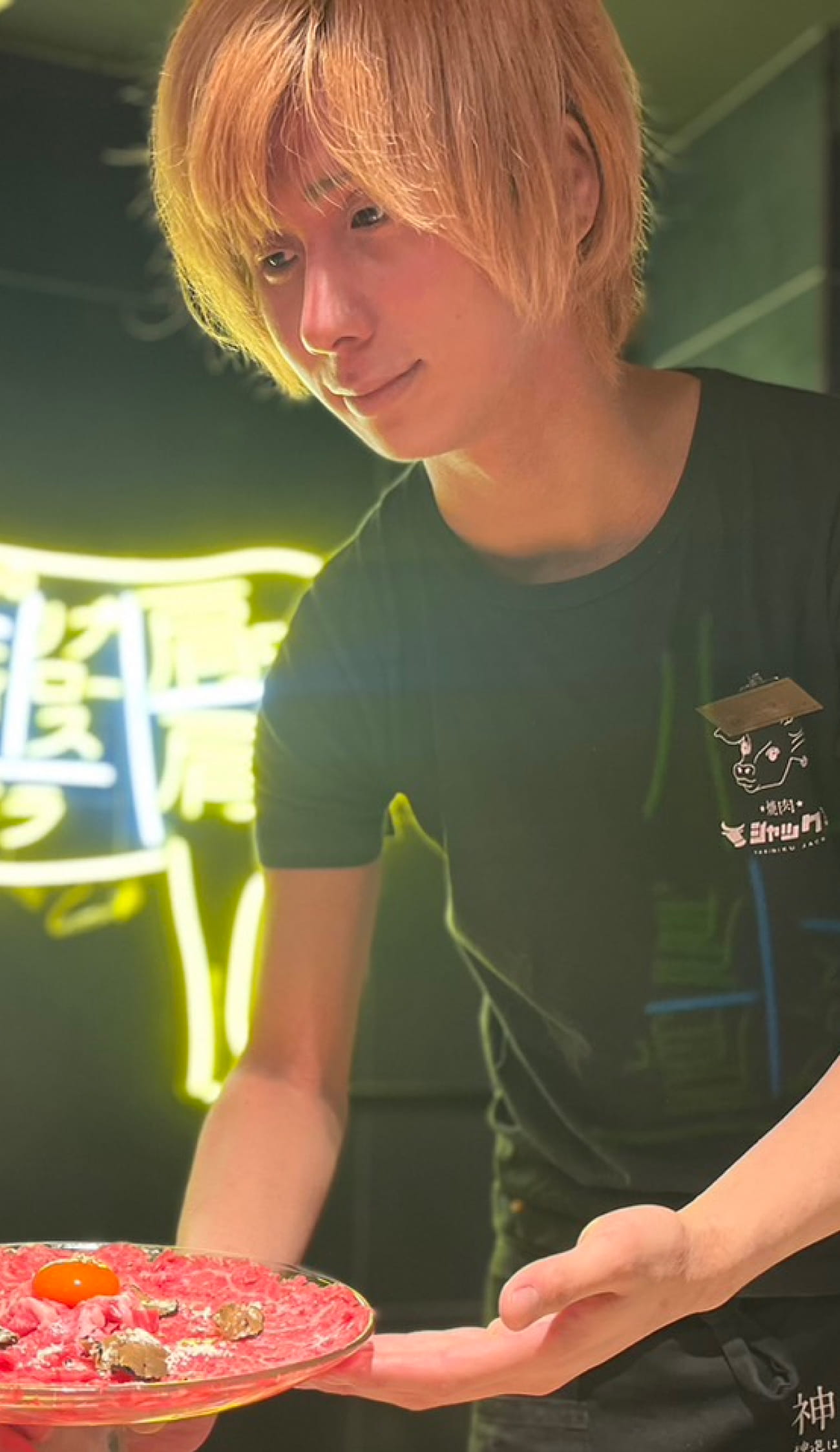 黒木さんがお客様に肉を提供している様子