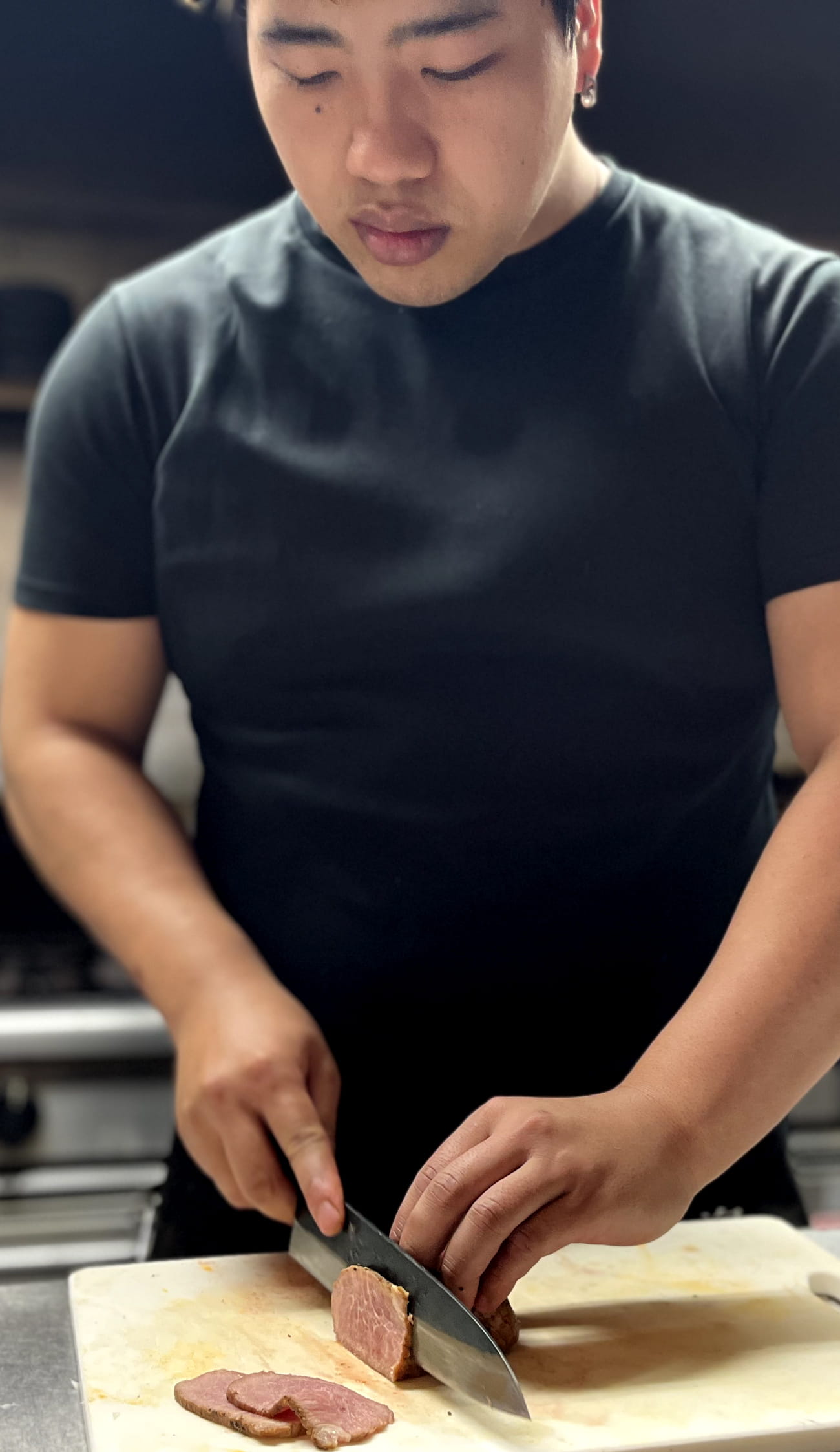 山本さんが調理場で肉をカットしている様子
