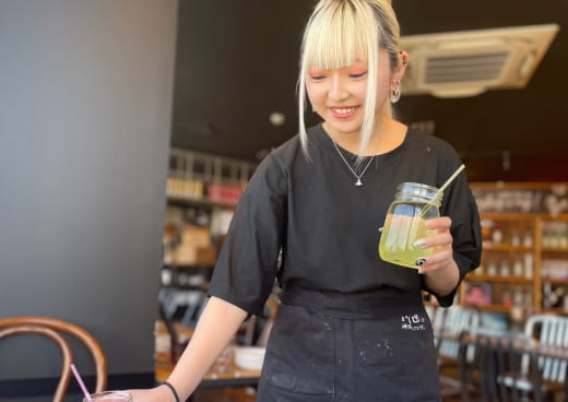 女性店員が笑顔で飲み物を提供している様子